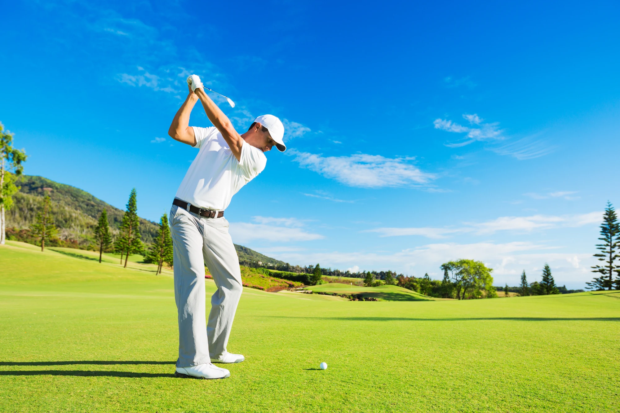 Golfista realizando un tiro con driver en campo de golf mexicano